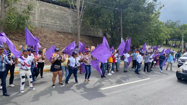 Peledeístas reciben vacacionistas ondeando banderas y pancartas